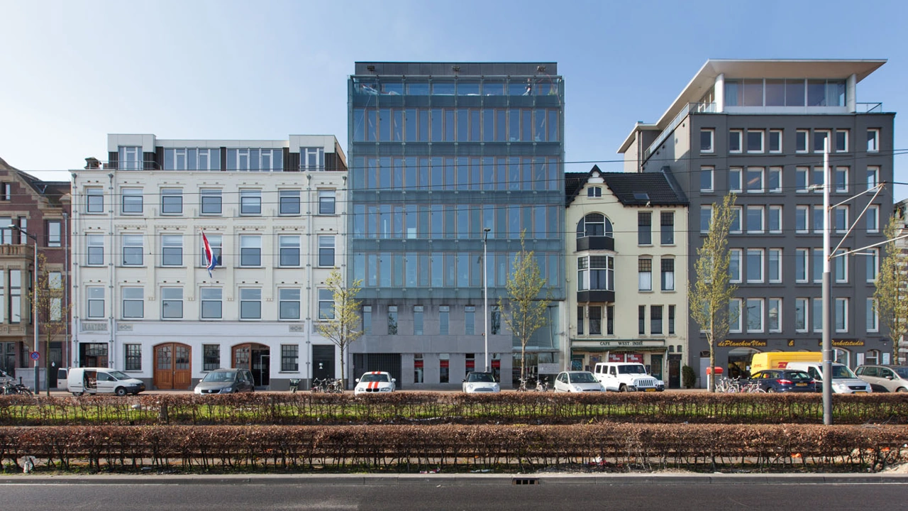 Rij gebouwen aan de De Ruijterkade in Amsterdam met een mix van klassieke en moderne architectuur.